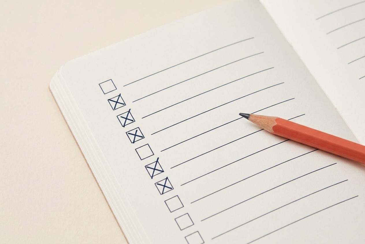 Daftar checklist belajar keuangan pribadi dengan kotak centang pada buku catatan